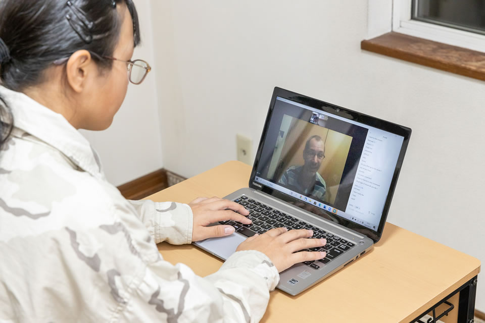 パソコンを使い１対１でオンライン英会話で学習している女子生徒の写真