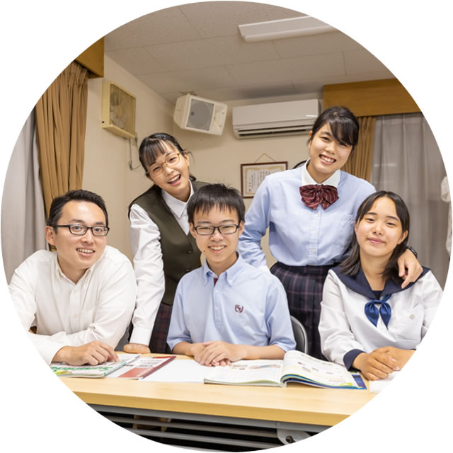 塾の介の仲良し生徒さん4人と渡邊先生が笑顔で肩を組んで座っている写真