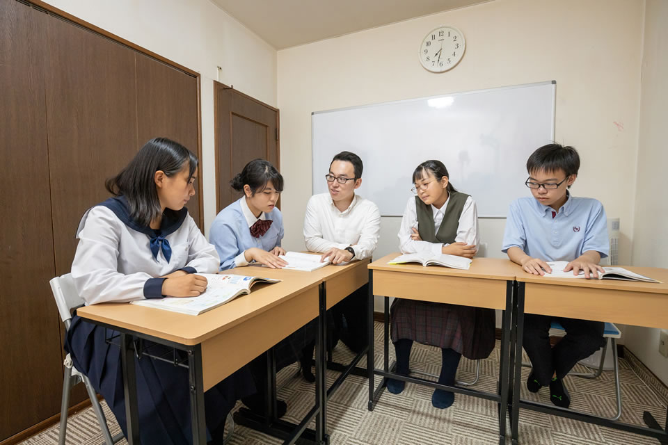 渡邊先生を囲んで生徒5人が個別に質問をして授業を受けている写真